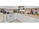 Spacious kitchen featuring white cabinets, light countertops and stainless appliances including a range and coffee maker at 3714 N Garrison St, Tampa, FL 33619