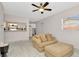 Living room with light tile floors featuring a pass through to the kitchen and a comfortable sofa at 3714 N Garrison St, Tampa, FL 33619