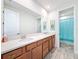 Bathroom with a large mirror over a double sink vanity with wood-look flooring at 4080 Bonfire Dr, Odessa, FL 33556