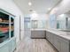 Spacious bathroom with dual vanities, quartz countertop, wood-look tile flooring, and linen cabinet at 4080 Bonfire Dr, Odessa, FL 33556