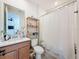 Bathroom with light wood-look flooring, a shower with a white curtain, and a wooden storage shelf at 4080 Bonfire Dr, Odessa, FL 33556