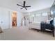 A bright bedroom featuring carpet flooring, a ceiling fan, and an ensuite bathroom at 4080 Bonfire Dr, Odessa, FL 33556