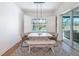 Bright dining area featuring modern lighting, white table, and bench seating, with a view of the pool area at 4080 Bonfire Dr, Odessa, FL 33556