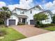Two-story home featuring a brick driveway, well-maintained landscaping, and double garage with a basketball hoop at 4080 Bonfire Dr, Odessa, FL 33556