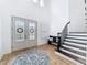 Bright and open foyer featuring hardwood floors, a staircase, shiplap accent wall, and double glass doors at 4080 Bonfire Dr, Odessa, FL 33556
