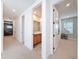 Upstairs hallway with several doorways leading to rooms, as well as neutral-toned walls and carpet at 4080 Bonfire Dr, Odessa, FL 33556