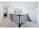 Upstairs hallway with a decorative light fixture, carpet flooring, and a modern railing at 4080 Bonfire Dr, Odessa, FL 33556