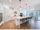 Modern kitchen with white cabinetry, stainless steel appliances, quartz countertops, and a large center island with seating at 4080 Bonfire Dr, Odessa, FL 33556