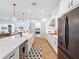 Bright kitchen featuring a large island, white cabinets, stainless steel appliances, and modern pendant lighting at 4080 Bonfire Dr, Odessa, FL 33556