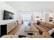 Bright living room with hardwood floors, a sectional sofa, and shiplap accent wall that opens to the kitchen at 4080 Bonfire Dr, Odessa, FL 33556