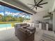 Covered outdoor space featuring a grill area, bar fridge and comfortable seating by the pool at 4080 Bonfire Dr, Odessa, FL 33556