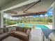 Inviting pool area with covered seating, a lush landscape, and outdoor dining at 4080 Bonfire Dr, Odessa, FL 33556