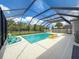 Sparkling pool with a screened enclosure, comfortable seating, and sunny skies at 4080 Bonfire Dr, Odessa, FL 33556