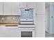 Kitchen area showcases modern white appliances and a unique blue and earth tone backsplash at 4530 Catalonia S Way, St Petersburg, FL 33712