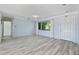 Open living room with light gray flooring, a large window, and a view of the front yard offers a welcoming space at 4530 Catalonia S Way, St Petersburg, FL 33712