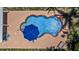 Aerial view of a kidney-shaped pool with patio, blue umbrella, lounge chairs and tropical landscaping at 4530 Catalonia S Way, St Petersburg, FL 33712