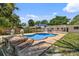 A refreshing backyard pool is enhanced by statues, lush landscaping, and a patio cover at 4530 Catalonia S Way, St Petersburg, FL 33712