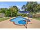 A refreshing backyard pool features a patio umbrella and lush landscaping at 4530 Catalonia S Way, St Petersburg, FL 33712