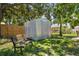 A backyard shed with a bench provides extra storage, complemented by mature trees at 4530 Catalonia S Way, St Petersburg, FL 33712
