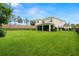 Expansive backyard with lush green lawn and a covered patio at 4607 Los Robles Ct, Palmetto, FL 34221