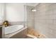 Bathroom featuring tiled walk-in shower, soaking tub and decorative accents at 4607 Los Robles Ct, Palmetto, FL 34221