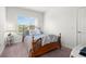 Bright bedroom featuring a wooden bed frame, window, and neutral tones at 4607 Los Robles Ct, Palmetto, FL 34221