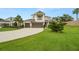 Charming two-story home with a large manicured front lawn, a three-car garage, and a second-story balcony at 4607 Los Robles Ct, Palmetto, FL 34221
