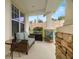 Covered patio with cozy seating area, brick accents, and view of the landscaped yard at 4607 Los Robles Ct, Palmetto, FL 34221
