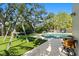 Spacious backyard with lush green lawn, pool, swing set, and patio furniture at 4722 W Laurel Rd, Tampa, FL 33629