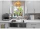 Farmhouse sink with a view; white cabinetry, quartz countertops, and stainless appliances at 4722 W Laurel Rd, Tampa, FL 33629