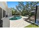 Backyard pool and patio with lounge seating, a grill, and mature landscaping at 4722 W Laurel Rd, Tampa, FL 33629