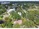 An aerial view shows mature trees surrounding this home, with a patio, pool, and lush landscaping at 5107 W Azeele St, Tampa, FL 33609
