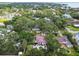 Aerial view of property with a pool, patio, and lush landscaping surrounded by mature trees in a desirable neighborhood at 5107 W Azeele St, Tampa, FL 33609