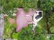 Aerial view of a home with a unique roofline, backyard pool, stone patio, and lush greenery at 5107 W Azeele St, Tampa, FL 33609
