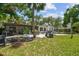 Lush backyard and home exterior with a unique pool ready for renovation and green lawn at 5107 W Azeele St, Tampa, FL 33609