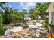 Secluded backyard features a stone patio area with a small pool, mature trees, and ample space for outdoor gatherings at 5107 W Azeele St, Tampa, FL 33609