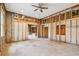 Spacious bedroom with partially finished walls, ceiling fan, exposed rafters, and doorway at 5107 W Azeele St, Tampa, FL 33609
