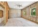 Bedroom with partially finished walls, ceiling fan, windows, and unfinished flooring at 5107 W Azeele St, Tampa, FL 33609