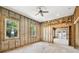 Bedroom featuring partially finished walls, ceiling fan, exposed rafters, and doorway at 5107 W Azeele St, Tampa, FL 33609