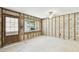 Spacious living room with exposed framing, a large window for natural light, and new flooring at 5107 W Azeele St, Tampa, FL 33609