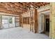 Open-concept living room with tile flooring, exposed rafters, doorway to patio, and access to other rooms at 5107 W Azeele St, Tampa, FL 33609