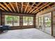 Sunroom with exposed wooden beam ceiling, tiled floor, large windows, and access to an outdoor deck area at 5107 W Azeele St, Tampa, FL 33609