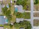 An aerial view displays the home's screened pool, lush landscaping, and proximity to neighborhood amenities at 5112 Odin St, Spring Hill, FL 34608
