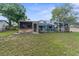 Backyard view of a screened in pool, a covered outdoor kitchen and an open grass area at 5112 Odin St, Spring Hill, FL 34608