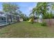 Large backyard featuring a screened-in pool, covered lanai, playground set and mature trees at 5112 Odin St, Spring Hill, FL 34608