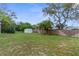 A sprawling backyard features lush greenery, a storage shed, and a wood fence at 5112 Odin St, Spring Hill, FL 34608