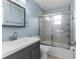 Blue bathroom with a modern vanity, tiled shower, and glass door at 5112 Odin St, Spring Hill, FL 34608