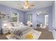 Light purple bedroom with mirrored closet doors, a ceiling fan, and a well-appointed bed at 5112 Odin St, Spring Hill, FL 34608