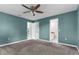 Teal bedroom with three doors, carpet floor, and a ceiling fan at 5112 Odin St, Spring Hill, FL 34608