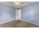 A light purple empty bedroom with carpet, a ceiling fan, and a door leading to another room at 5112 Odin St, Spring Hill, FL 34608